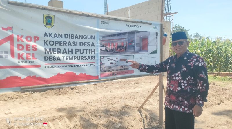 Kades Tempursari H. Budi Diyatmiko, Bsc tunjukkan papan desain gedung KDMP di selatan jembatan Bantengan.